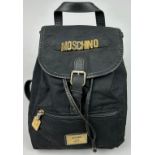 A VINTAGE MOSCHINO BACKPACK RUCKSACK, black with gold hardware spelling out 'Moschino' with