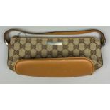 A SMALL GUCCI SHOULDER BAG IN BEIGE, with interlocking 'GG' emblem throughout, tan leather strap and