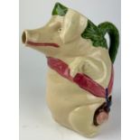 A MAJOLICA PIG JUG, depicting a pig holding a ham 22cm in height