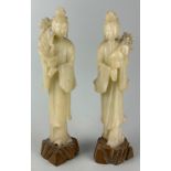 TWO MODERN CARVED JADE CHINESE FIGURES OF WOMEN HOLDING FLOWERS, Marked ‘China’ to verso. 30cm H