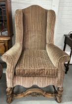 A QUEEN ANNE STYLE WINGBACK ARMCHAIR, Velvet upholstered with heavily carved walnut apron and