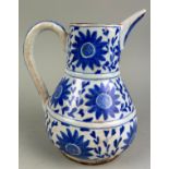 AN ISLAMIC JUG BLUE AND WHITE PAINTED WITH FLOWERS 21cm in height