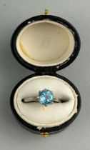 A PLATINUM RING INSET WITH A BLUE GEMSTONE most likely aquamarine, within a small black case.