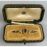 A GOLD BROOCH, Inset with amethyst surrounded by a rope twist border and flanked by two clusters