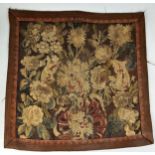 A 17TH CENTURY TAPESTRY FRAGMENT DEPICTING FLOWERS 55cm x 55cm