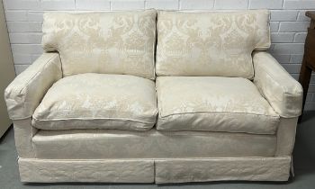 A TWO-SEATER CONTEMPORARY WHITE SOFA UPHOLSTERED IN LINEN FABRIC WITH BIRD AND FOLIAGE PATTERN.