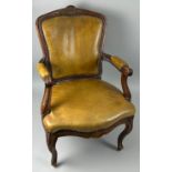 A 19TH CENTURY FRENCH WALNUT FAUTEUIL, The shaped back tan leather upholstered with carved flower