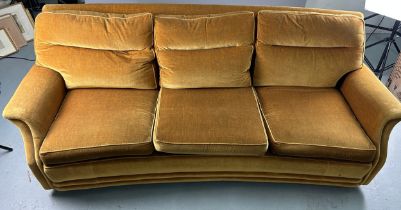 A MID CENTURY DESIGN THREE-SEATER SOFA The curved frame upholstered in green velvet fabric, raised