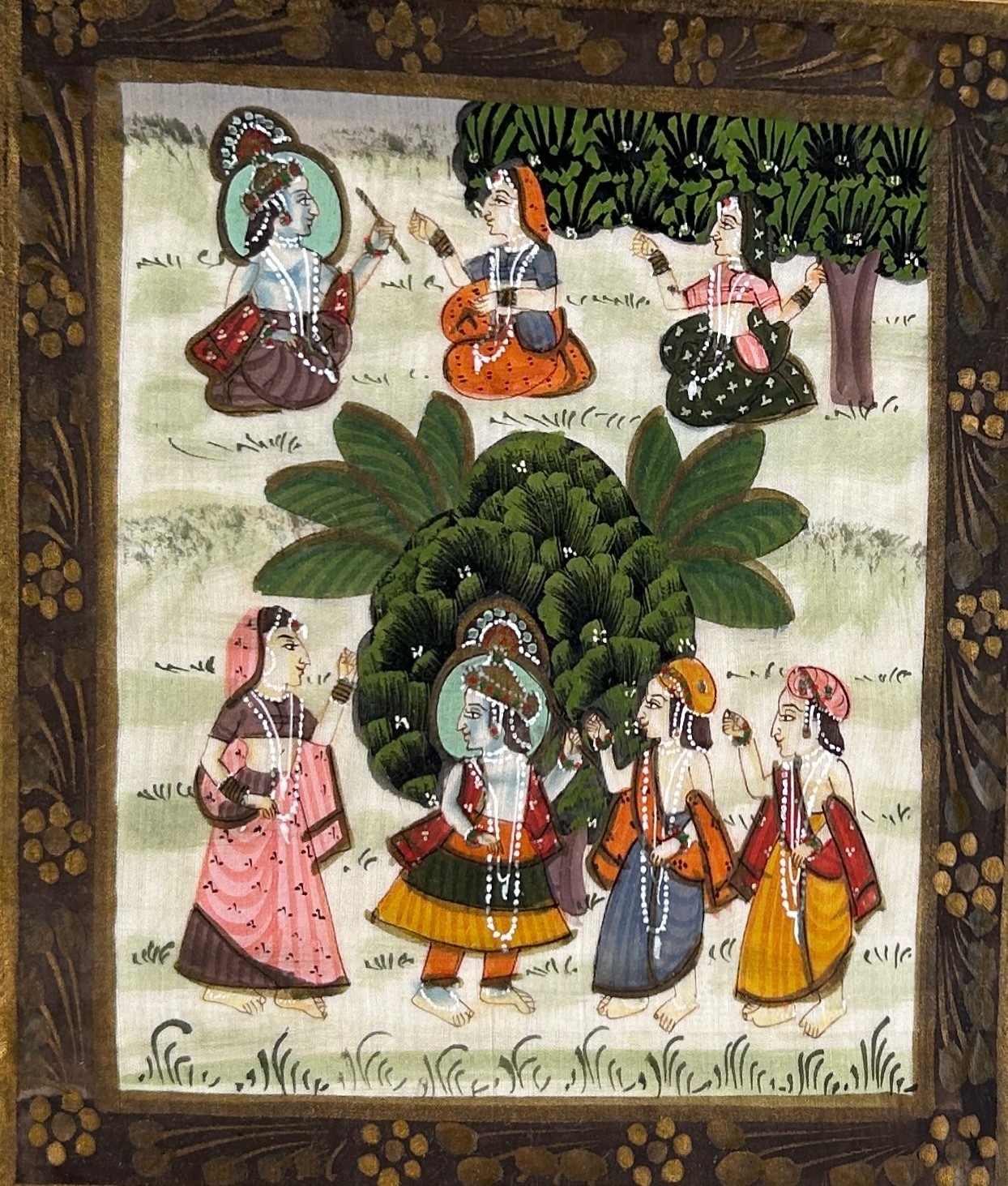 AN INDIAN PAINTING ON SILK DEPICTING SEVEN LADIES IN TRADITIONAL DRESS, Mounted in a frame and