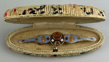 A PERSIAN YELLOW METAL AND ENAMELLED BROOCH, Decorated with a crown and flowers, housed inside a box