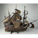 A CARVED WOODEN MODEL OF A GALLEON WITH FLAGS AND CANONS, 80cm x 65cm