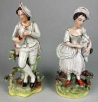 A PAIR OF STAFFORDSHIRE POTTERY FIGURES HOLDING ANIMALS, 23cm h (each) (2)