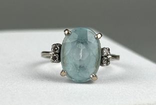 A PLATINUM RING, INSET WITH AN AQUAMARINE STONE, claw set and flanked with two diamonds on either
