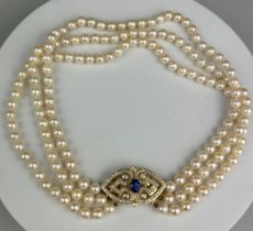 A NECKLACE OF CULTURED PEARLS, JOINED BY A 14CT GOLD, DIAMOND CLASP SET WITH A BLUE STONE, This