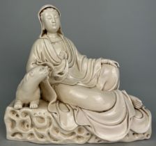 A CHINESE BLANC DE CHINE GROUP OF A SEATED GUANYIN WITH A LION, 25cm h x 27cm w Impressed mark to