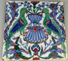 AN IZNIK GLAZED TILE DECORATED WITH TWO BIRDS SURROUNDED BY FLOWERS, 24. 5 x 24.5cm
