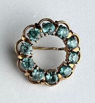 A GOLD FLORAL BROOCH, WITH TEN CLAW SET CIRCULAR CUT AQUAMARINES. Weight 6.0gms.