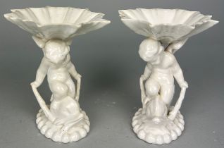 A PAIR BLANC DE CHINE DISHES OF CUPID RIDING A DOLPIN AND HOLDING A SHELL, 17cm h x 16cm w (each) (