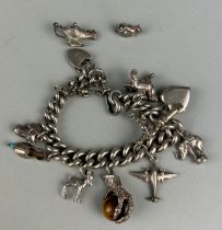 A SILVER CHARM BRACELET, WITH VARIOUS ASSORTED CHARMS INCLUDING AN INTERESTING CLAW GRASPING A STONE