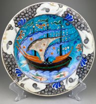 AN UNUSUAL IZNIK GLAZED PLATE PAINTED WITH BOATS AND FISH, 31cm diameter