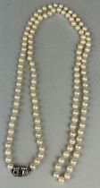 A LONG-CULTURED PEARL NECKLACE WITH WHITE GOLD CLASP, INSET WITH SMALL DIAMONDS AND SAPPHIRES (2)