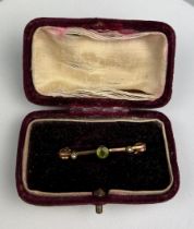 A 9CT GOLD BROOCH INSET WITH PERIDOT AND TWO SMALL SEED PEARLS, Marked '9CT'