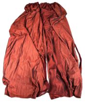 A PAIR OF RED SILK CURTAINS, with velvet fringe and white interior. With tie backs. (2) 300cm x