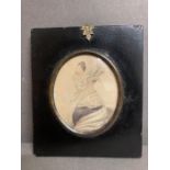 A framed miniature portrait of a llady with white lace collar and bonnet with description verso