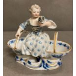 A blue and white Meissen porcelain salt and pepper of a young girl sitting between two baskets AF