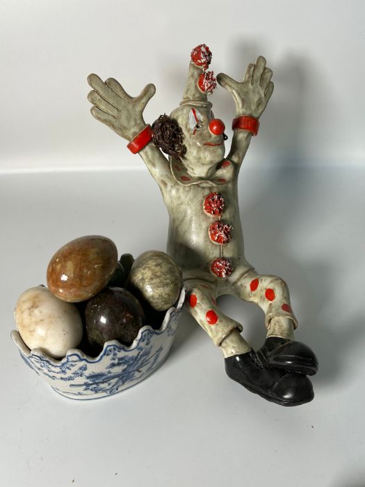 Blue and white pot with marble eggs and a clown