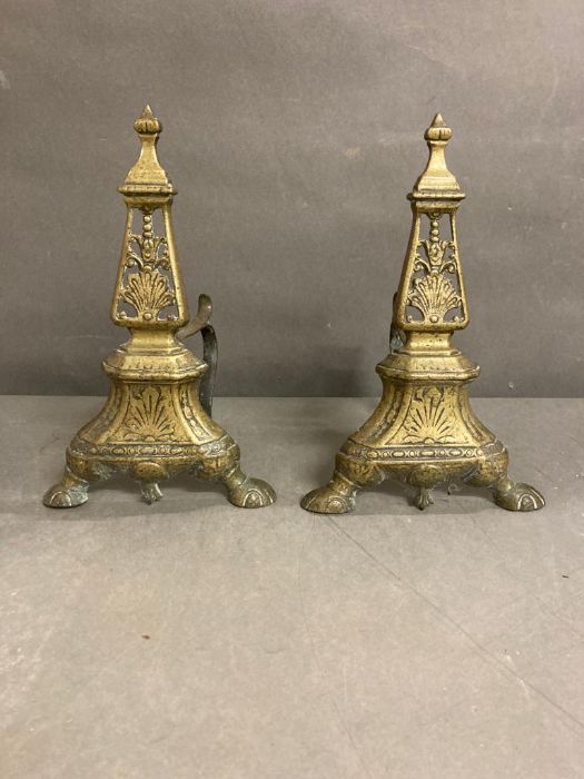 A pair of brass fire dogs