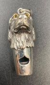 A silver dogs head whistle.