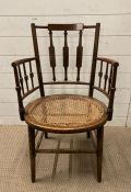 An aesthetic movement mahogany cane seated arm chair
