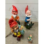 Three garden gnomes, two with fish and one on a swing