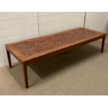 A teak Mid Century style coffee table with red tiled top (H40cm W170cm D63cm)