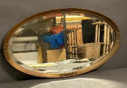 A Mid Century gilt framed oval wall mirror