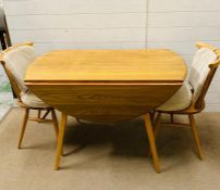 A blonde ercol table and two chairs