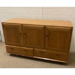 An Ercol three sideboard / cupboard, two drawer dresser on castors (H76cm W130cm D44cm)