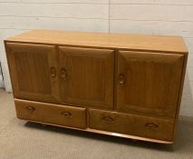 An Ercol three sideboard / cupboard, two drawer dresser on castors (H76cm W130cm D44cm)