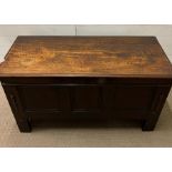 An oak three panelled oak coffer with bracket feet and hinged lid (H72cm W132cm D57cm)