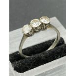 A Platinum set three stone diamond ring. Size Q