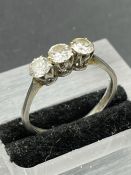 A Platinum set three stone diamond ring. Size Q