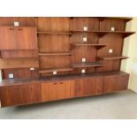A Mid Century teak wall unit consisting of four bays with movable shelfs and cupboards in a G-Pan