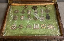 A cased selection of Irish regiment military cap badges and insignia.