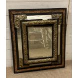 A rectangular mirror with ebonised wood and brass rejected