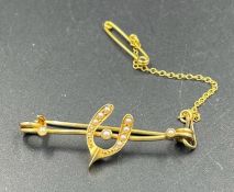 A gold lucky horseshoe themed brooch with seed pearls and safety chain (Approximate Total Weight 2.