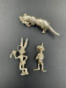 Two silver charms of Bugs Bunny and Daffy Duck along with a silver otter.