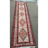 A hand tied runner rug with five medallions (293cmx 76cm)