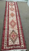 A hand tied runner rug with five medallions (293cmx 76cm)