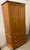 A pine wardrobe over three drawers (H183cm W83cm D58cm)